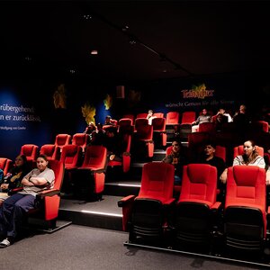 Abbildung einer Gruppe Jugendlicher, die gemeinsam einen Film im Kinosaal anschauen