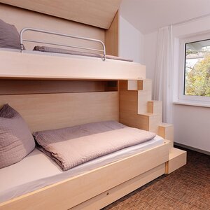 Image of a wooden double bed from the side