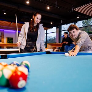 Abbildung zweier Bewohner, die zusammen Pool spielen
