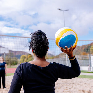 Abbildung einer Gruppe Bewohner, die zusammen Volleyball spielt