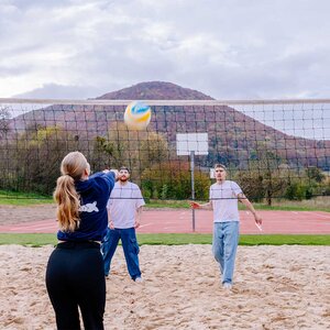 Abbildung einer Gruppe Bewohner, die zusammen Volleyball spielt
