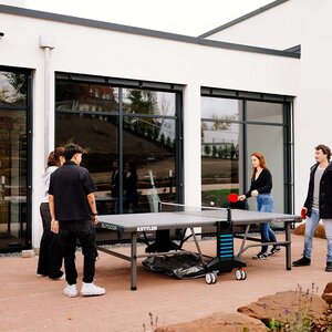 Abbildung einer Gruppe Bewohner, die zusammen Tischtennis spielen