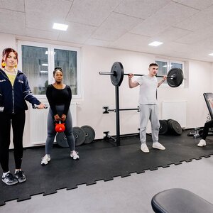 Abbildung einer Gruppe Bewohner, die zusammen in einem Fitnessraum trainieren