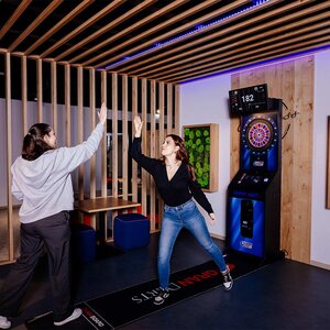 Abbildung zweier Bewohner, die zusammen Darts spielen