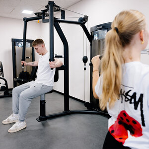 Abbildung zweier Bewohner, die zusammen in einem Fitnessraum trainieren