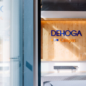 Image of a wooden wall with the DEHOGA logo on it