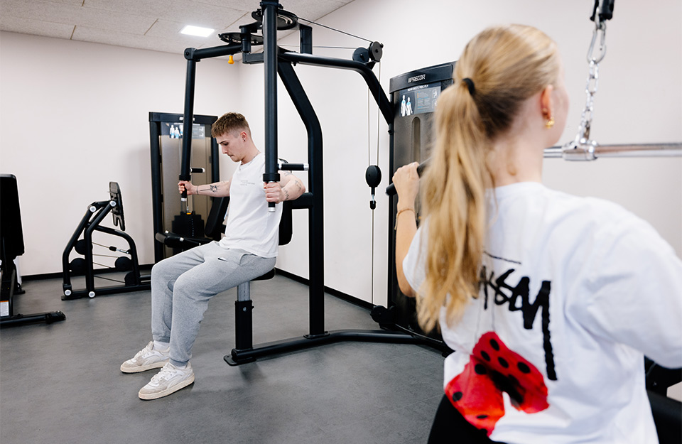 Abbildung zweier Bewohner des Campus Bad Überkingen, die im Fitnessraum trainieren