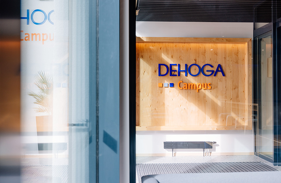 Abbildung einer Holzwand auf der das Logo von DEHOGA-Campus zu sehen ist