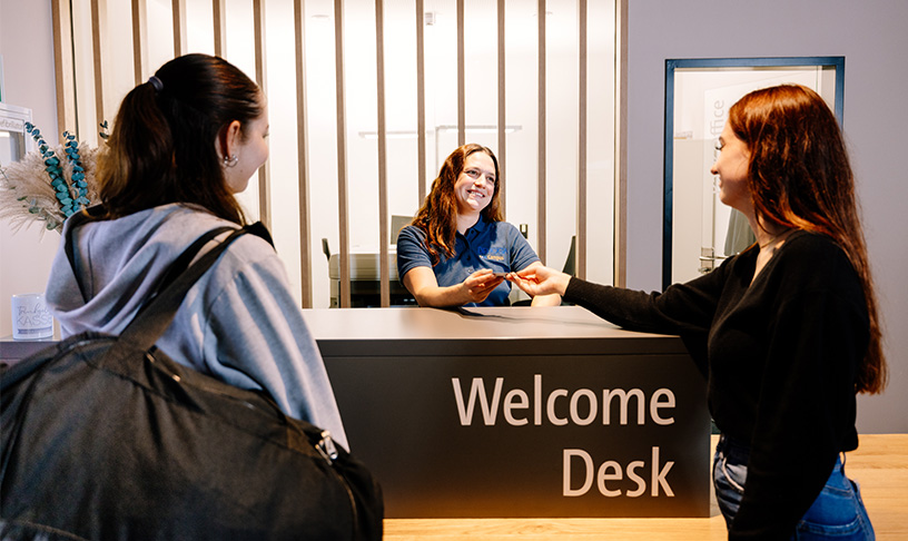 Image of a receptionist welcoming two guests