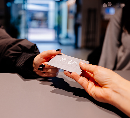 Close-up of a hand handing a business card to another hand